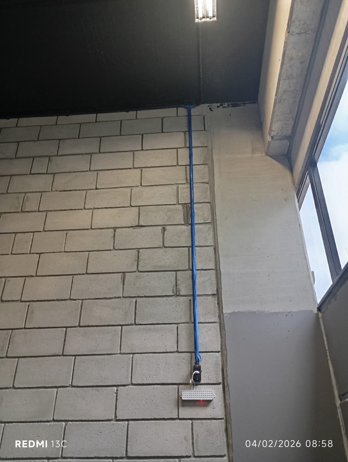 Eletroduto azul passando pelo piso com caixa de passagem